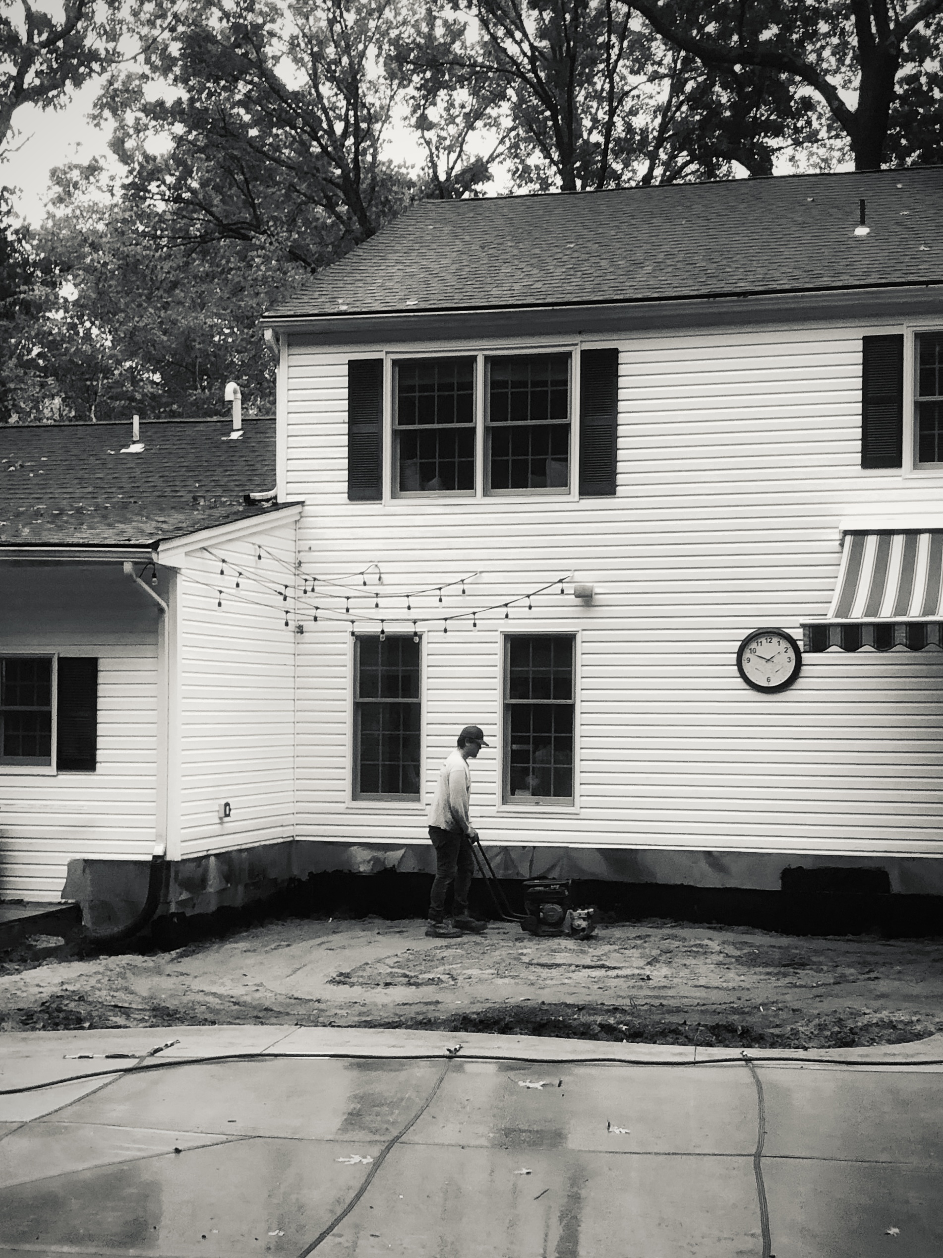 Landscaper preparing the ground for a backyard patio installation at a residential home.