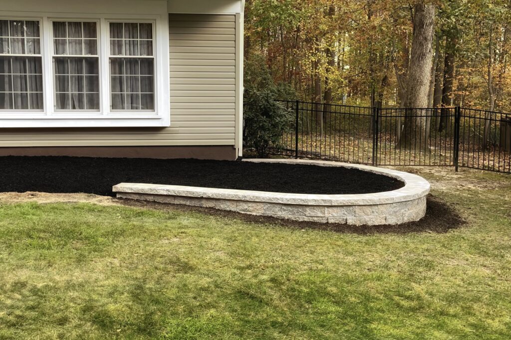 Completed front yard stone structure and planting bed installation by Green Horizon Landscape LLC