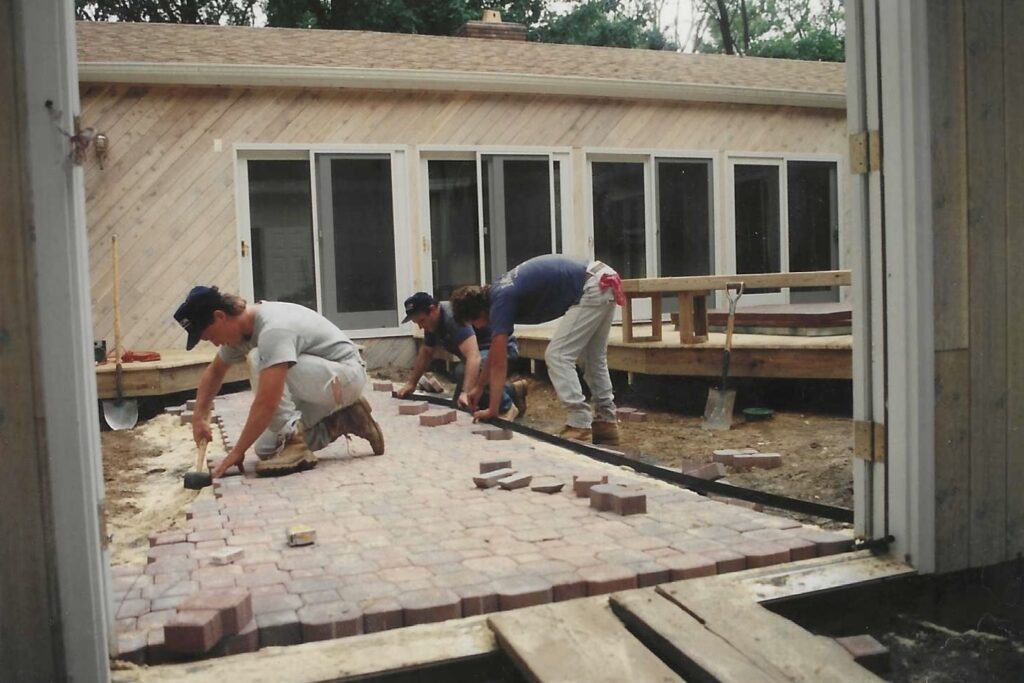 Green Horizon Landscape owner laying brick for a residential patio project in Middletown, NJ during the company’s early years